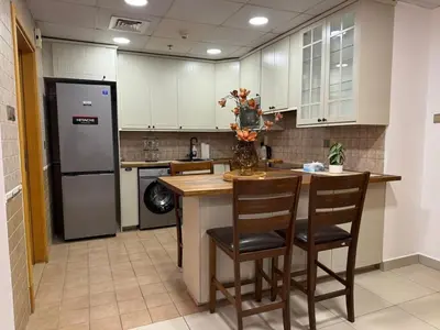 a kitchen with a counter with chairs and a refrigerator at Modern 1-BR in Armada Tower 3, JLT, Sky Views in Dubai