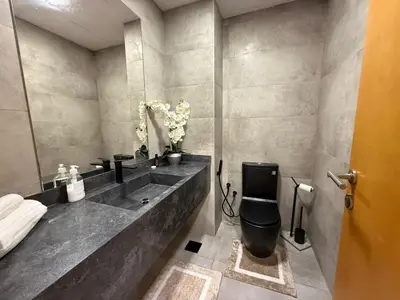 a bathroom with a black toilet and a sink at Modern 1-BR in Armada Tower 3, JLT, Sky Views in Dubai