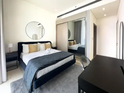a bedroom with a bed and a table and a mirror at High-End Living With Private Pool in Dubai