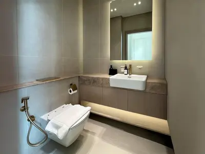 a bathroom with a toilet and a sink and a mirror at High-End Living With Private Pool in Dubai