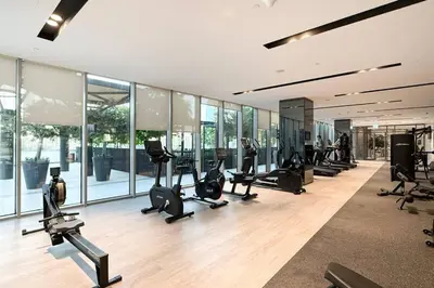 a gym with treadmills and ellipticals and windows at Mahogany 24 - 2BR 6 PAX - On the Boulevard Sea View in Dubai