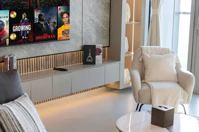 a living room with a tv and a chair at Mahogany 24 - 2BR 6 PAX - On the Boulevard Sea View in Dubai