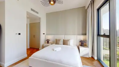 a bedroom with a white bed and a large window at Vacationer l Upgraded Aesthetic 2 Bed l near Dubai Hills Mall in Dubai