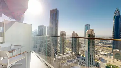 a person standing on a balcony with a view of a city at Vacationer l Elegant 2 Bed l near Burj Khalifa l Address Opera in Dubai