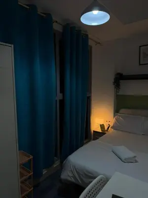 a bedroom with a bed with blue drapes at Modren Private Partition Room In Barsha Heights Tecom in Dubai