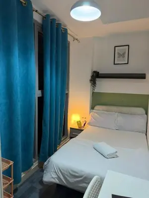 a bedroom with a large bed with blue curtains at Modren Private Partition Room In Barsha Heights Tecom in Dubai