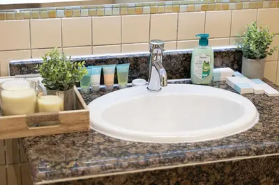 a bathroom counter with a sink and a bottle of soap at Luxe 4BR Upscale Beach Side Unit with Pool Table in Dubai