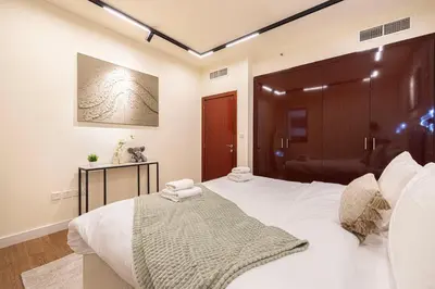 a bedroom with a large white bed with a wooden headboard at Luxe 4BR Upscale Beach Side Unit with Pool Table in Dubai
