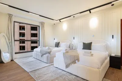 a white bedroom with two beds and a couch at Luxe 4BR Upscale Beach Side Unit with Pool Table in Dubai