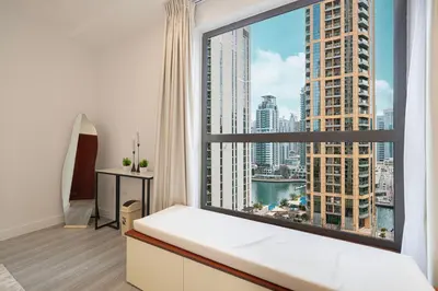 a bedroom with a large window with a view of a city at Chic JBR Apartment Beach Walk Dining Nightlife in Dubai