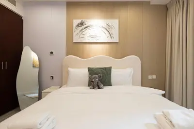 a teddy bear sitting on top of a bed at Chic JBR Apartment Beach Walk Dining Nightlife in Dubai