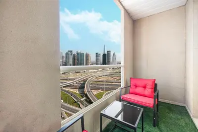 a red chair on a balcony with a view of a city at Luxury 3BHK with floating bed in Marina in Dubai