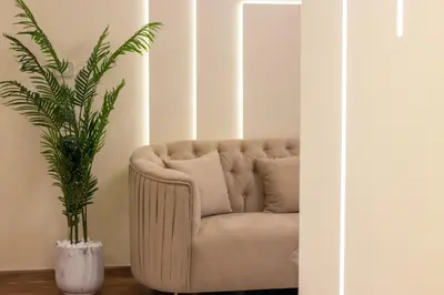 a couch in a living room with a plant at Luxury 3BR & Floating Bed in Marina with Pool in Dubai