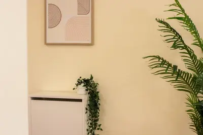 a room with a plant and a picture on the wall at Luxury 3BR & Floating Bed in Marina with Pool in Dubai