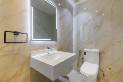 a bathroom with a sink and a toilet and a mirror at Lux 3BHK With Pvt Jacuzzi in Marina in Dubai