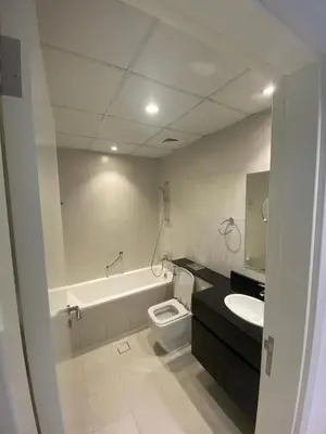 a bathroom with a tub and a toilet and a sink at Ghalia in Dubai