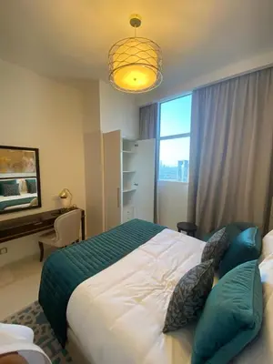 a bedroom with a bed and a desk and a window at Ghalia in Dubai