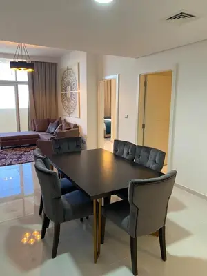 a dining room table and chairs in a living room at Ghalia in Dubai