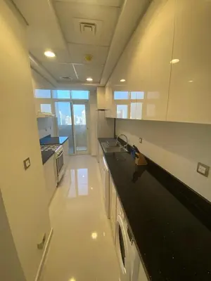a large white kitchen with a black counter top at Ghalia in Dubai