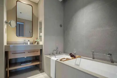 a bathroom with a tub and a sink and a mirror at Frank Porter - Vida Dubai Mall in Dubai