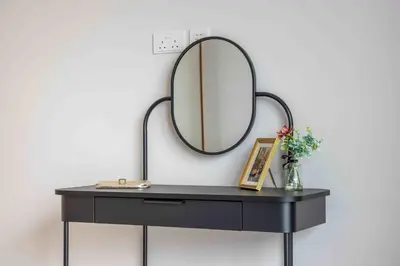 a black dressing table with a mirror on a wall at Frank Porter - Vida Dubai Mall in Dubai