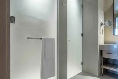 a bathroom with a shower with a towel and a sink at Frank Porter - Vida Dubai Mall in Dubai