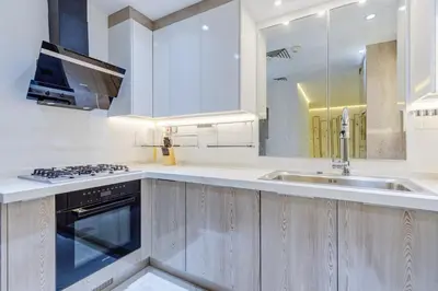 a white kitchen with a sink and a stove at Elegant 2-Bedroom Apartment in Marina Heights 1, Dubai Marina in Dubai