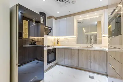 a large kitchen with wooden cabinets and stainless steel appliances at Elegant 2-Bedroom Apartment in Marina Heights 1, Dubai Marina in Dubai