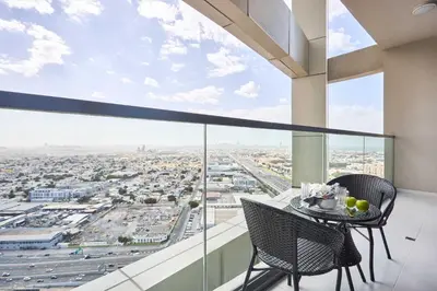 a table and chairs on a balcony with a view of a city at Frank Porter - Aykon City, Business Bay in Dubai
