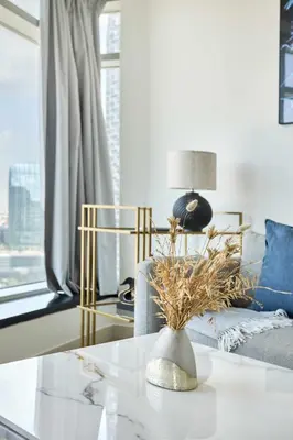 a living room with a couch and a table at Frank Porter - Loft Tower West in Dubai