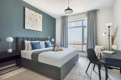 a bedroom with a large bed with a desk and a desk at Frank Porter - Loft Tower West in Dubai