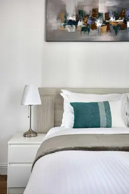 a bedroom with a white bed with a green pillow at Frank Porter - Damac Waves Tower, Dubai Marina in Dubai