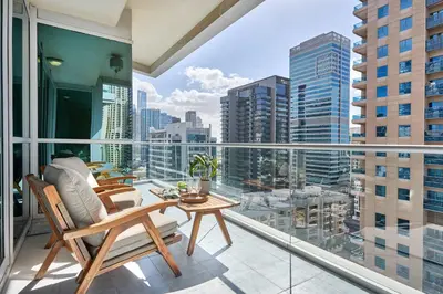 a balcony with chairs and a table and a view of the city at Frank Porter - Damac Waves Tower, Dubai Marina in Dubai