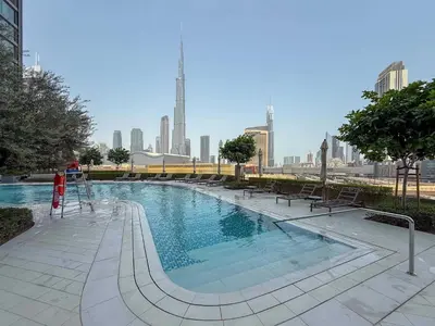 a large swimming pool with a city in the background at Frank Porter - Vida Dubai Mall in Dubai