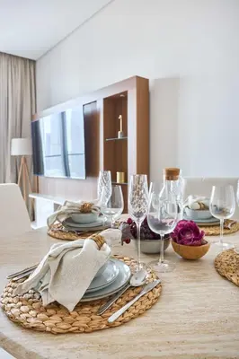 a dining room table with plates and wine glasses at Frank Porter - Vida Dubai Mall in Dubai