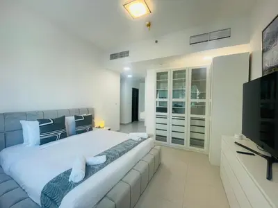 a large white bedroom with a large bed with a couch at Vezul Residence, Business Bay - 2 Bedroom Apartment - Allsopp & Allsopp in Dubai