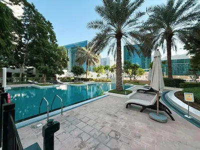 a pool with a chair and a umbrella and palm trees at Lux Unit Breathtaking Burj View I Walk Dubai Mall in Dubai
