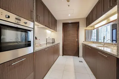 a large kitchen with wooden cabinets and a large window at Lux Unit Breathtaking Burj View I Walk Dubai Mall in Dubai