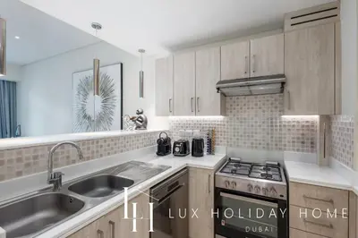 a kitchen with a sink and a stove at LUX The Seven Res Palm Suite in Dubai