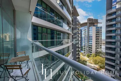 a balcony with a chair and views of the city at LUX The Seven Res Palm Suite in Dubai