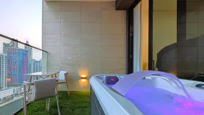 a hot tub on a balcony with a table and chairs at Sleek and Cozy Studio, Private Jacuzzi, Canal View in Dubai