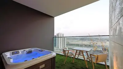 a jacuzzi tub in a room with a large window at Sleek and Cozy Studio, Private Jacuzzi, Canal View in Dubai