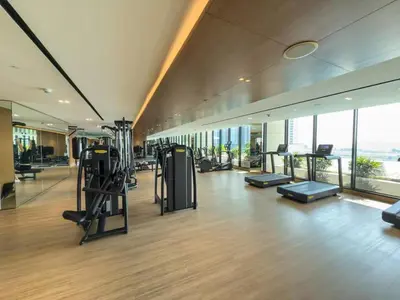 a gym with treadmills and exercise equipment in a building at Sleek and Cozy Studio, Private Jacuzzi, Canal View in Dubai