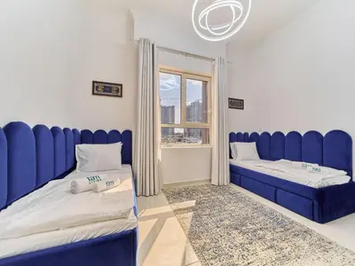 a room with two beds and a window at Cozy 2BR Canal Residence Sports City in Dubai