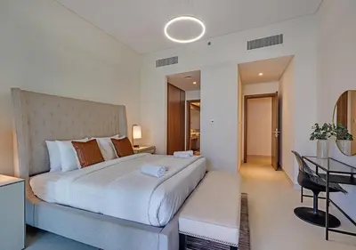 a bedroom with a large white bed and a table at Canal Front Residence 5, Al Wasl - 2 Bedroom with Maids room - Allsopp & Allsopp 02 in Dubai
