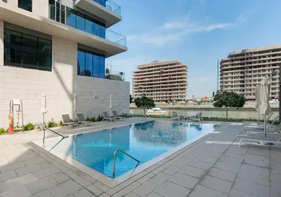 a large swimming pool next to a building at Canal Front Residence 5, Al Wasl - 2 Bedroom with Maids room - Allsopp & Allsopp 02 in Dubai