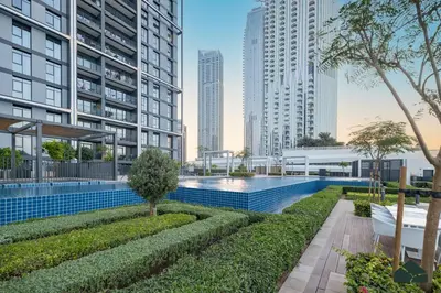 an image of a swimming pool in a city with tall buildings at Serene 2BR with Sea View by BMS in Dubai