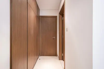 a hallway with wooden doors and a white floor at Canal Front Residence 5, Al Wasl - 2 Bedroom with Maids room - Allsopp & Allsopp 01 in Dubai