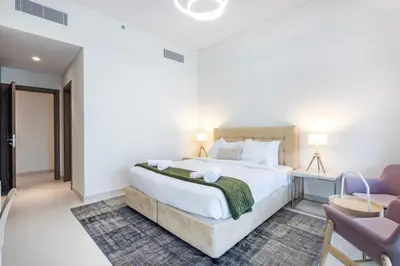 a bedroom with a large white bed and two chairs at Canal Front Residence 5, Al Wasl - 2 Bedroom with Maids room - Allsopp & Allsopp 01 in Dubai