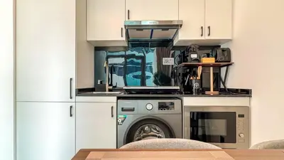 a kitchen with a washing machine and a microwave at Stylish 1BDR Centrally Located for 4 Persons in Dubai